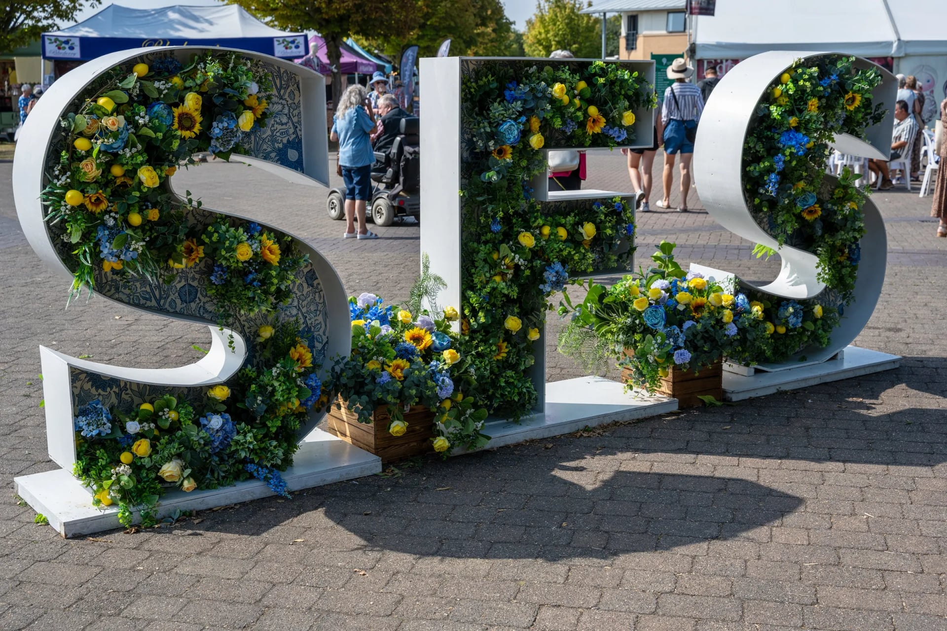 The SFS flower letters at Southport Flower Show, decorated with sunflowers and blue hydrangeas at Victoria Park